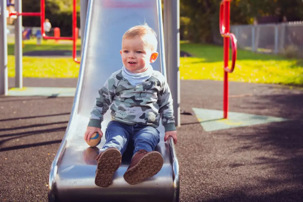 Families portfolio - a little boy on the bottom of a slide - Bedfordshire Family Photography