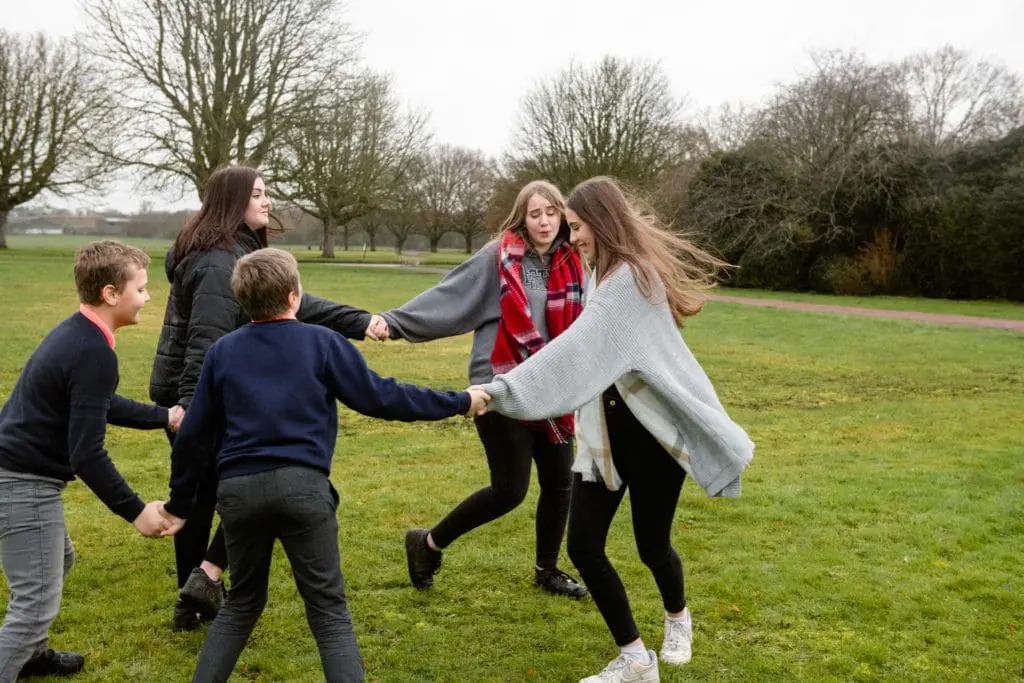 Families portfolio - children of ages 11-17 playing ring-a-roses in Wrest Park Bedfordshire family photography