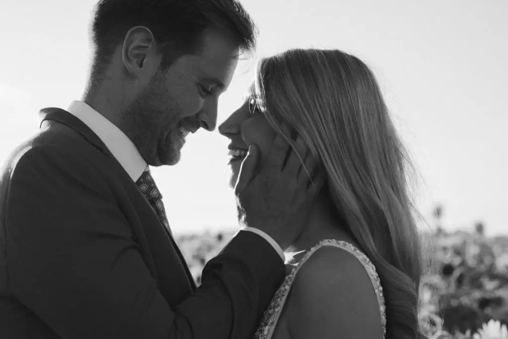 Close up of a bride and groom about to kiss, the groom is holding the bride's face gently