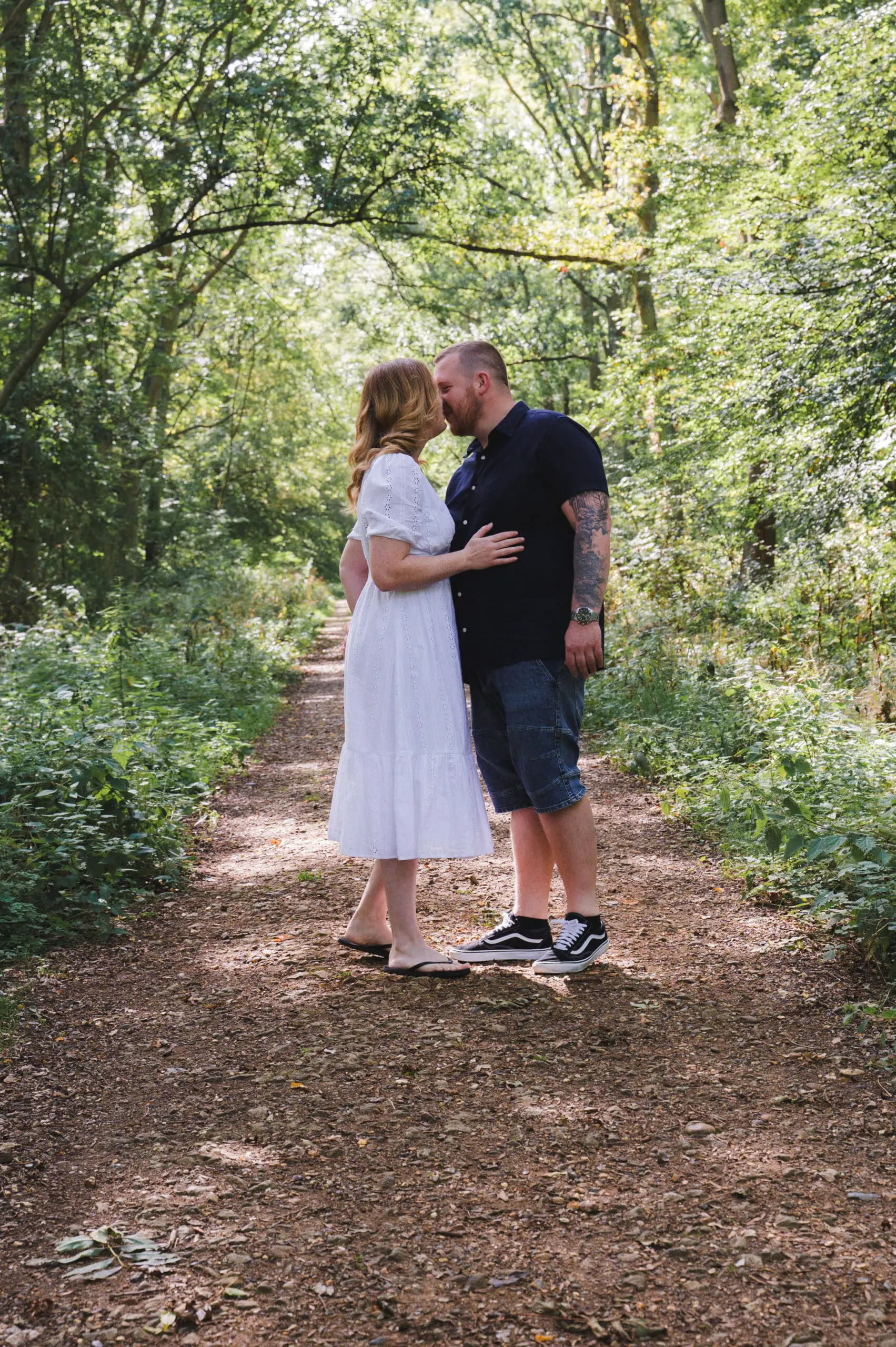 Wedding Photography in Bedfordshire A couple kissing under the shade of woodland trees