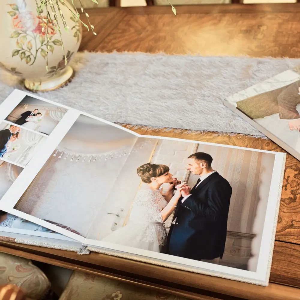 wedding album keepsake on a wooden table with a vase in the background