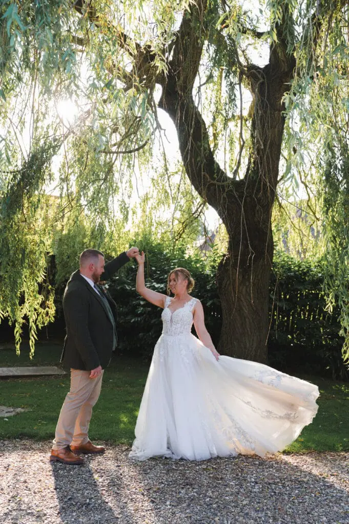 professional wedding vendors include a photographer, like myself, who took this image of a bride and groom dancing under a willow tree