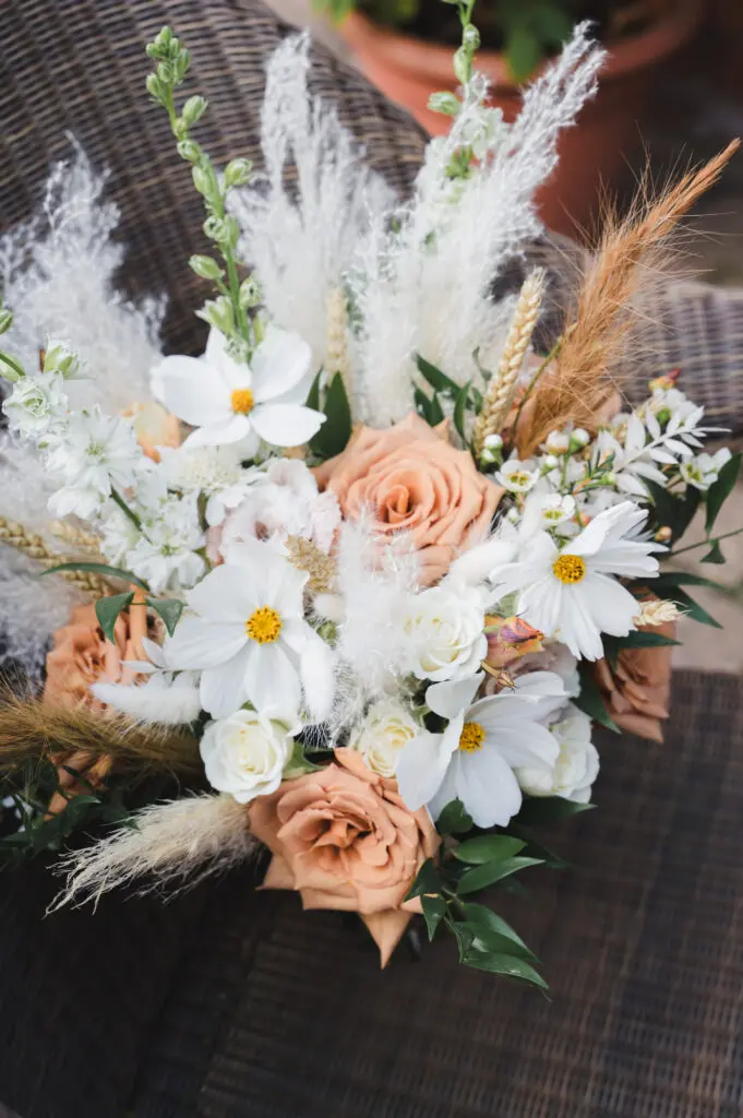 Weddings in Bedfordshire a natural bouquet of peach roses, delicate white flowers and fronds of wheat and fluffy seed stems