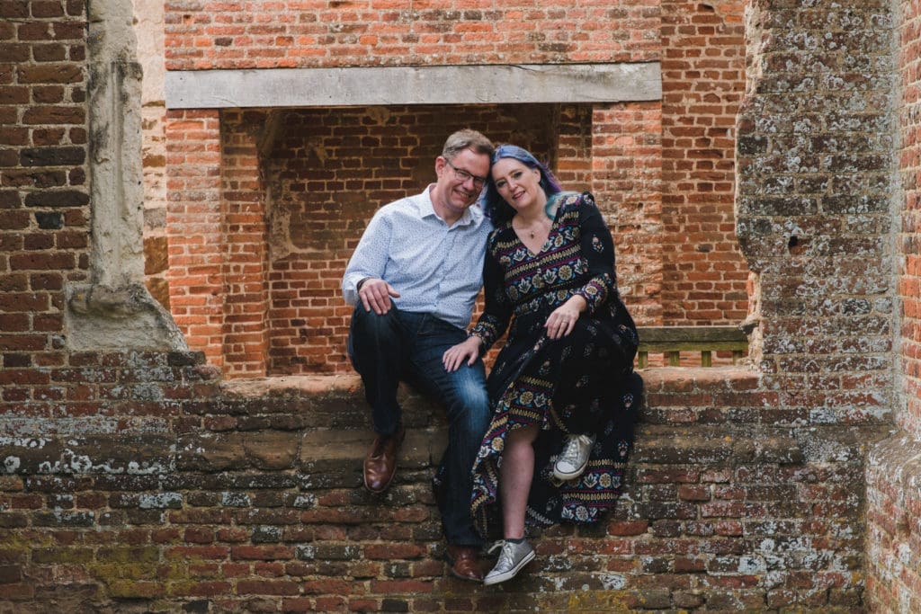 Engagements portfolio - a couple Sitting on a derelict red bricked wall