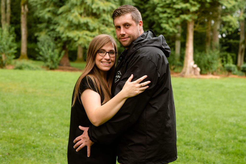 Engagements Portfolio - Couple looking at camera in a woodland setting