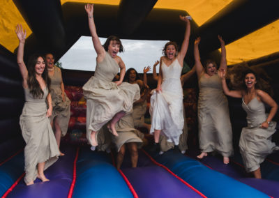 wedding photographer in Bedfordshire - Bride and Bridesmaids jumping on a bouncy castle