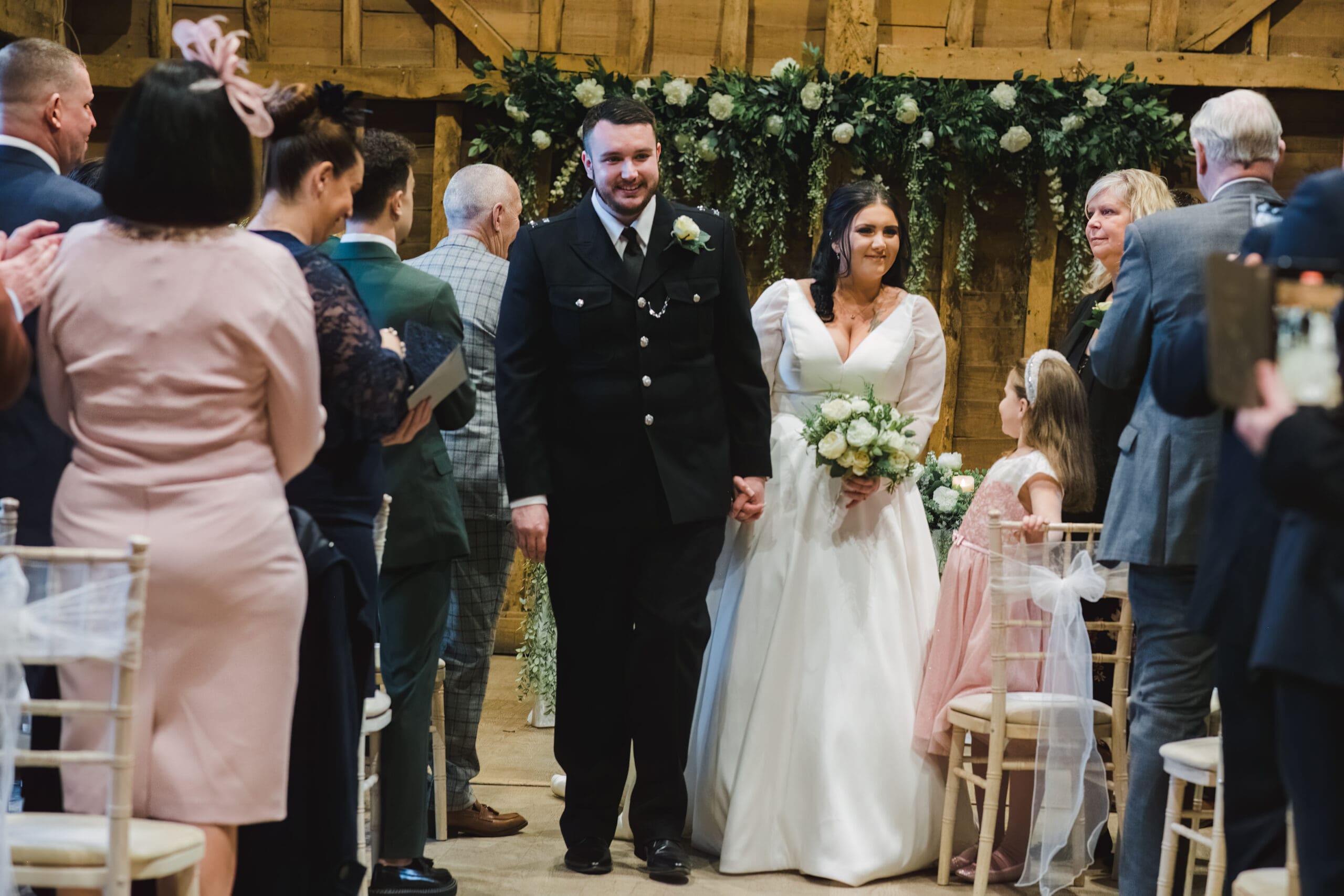 wedding at Tewenbury Farm - Just married the bride and groom walk past their guests back down the aisle