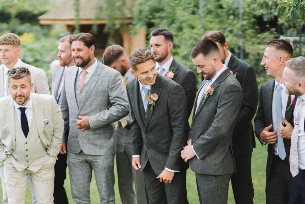 Wedding photography timeline - the groom and his groomsmen caught sharing a joke before they pose for a formal image