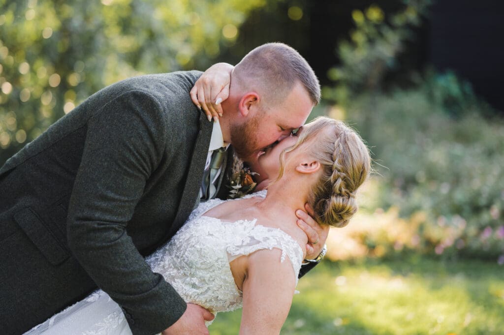 Wedding Photography Timeline - a bride and groom kissing in a dip pose outside.
